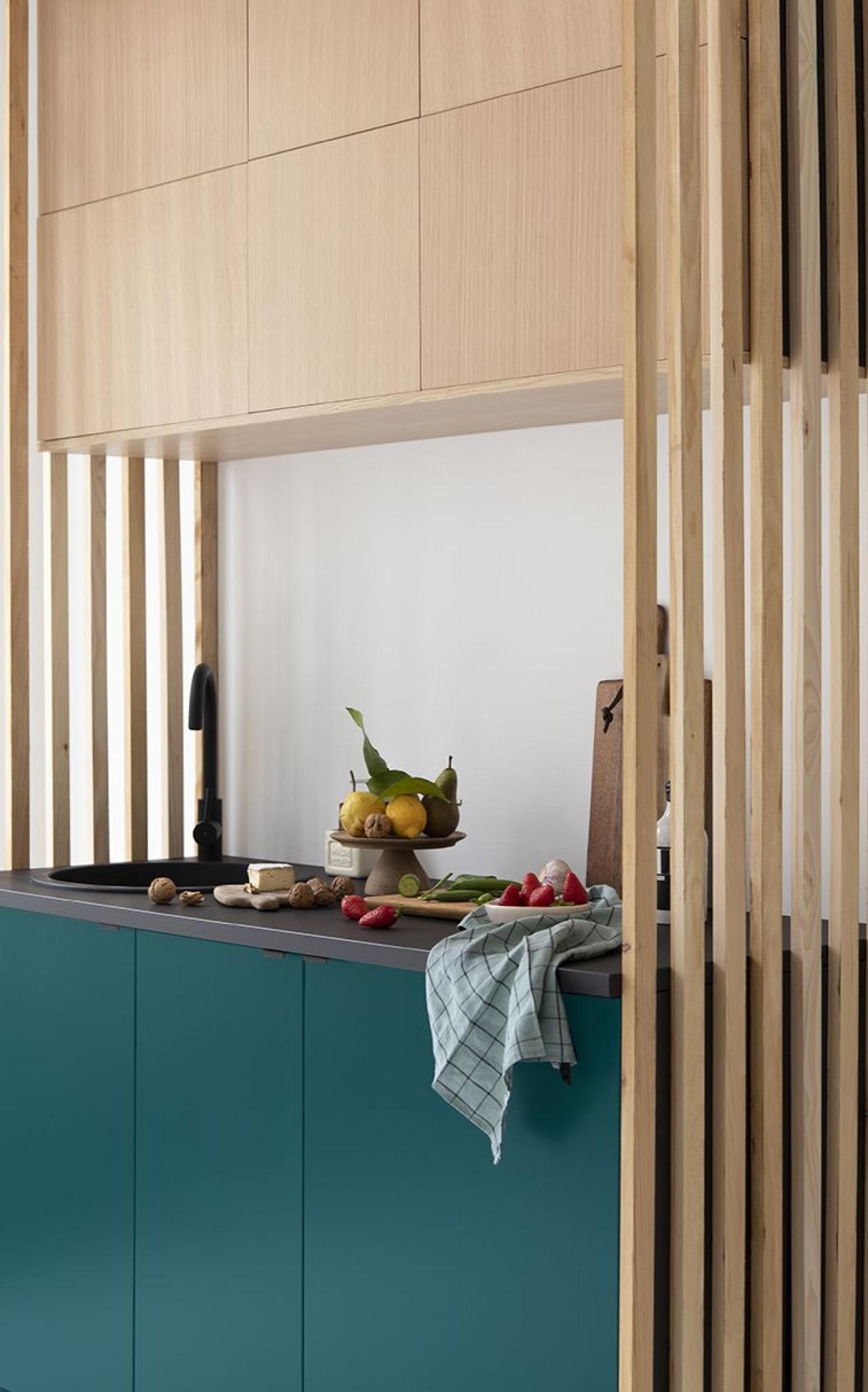 Une mini-cuisine en Chêne naturel et Vert sauvage encadrée par une claustra