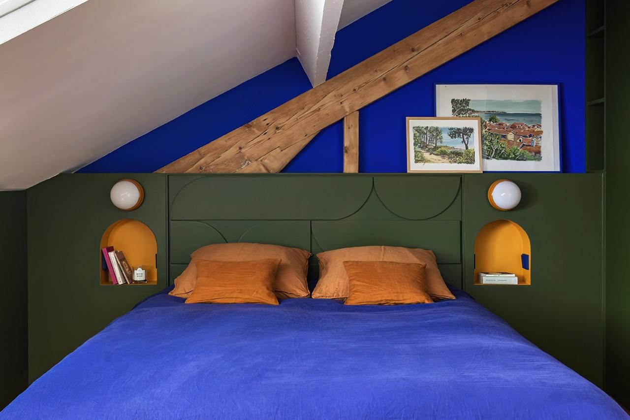 Attic room with intimate atmosphere, blue and yellow bedding with Olive headboard, with niches