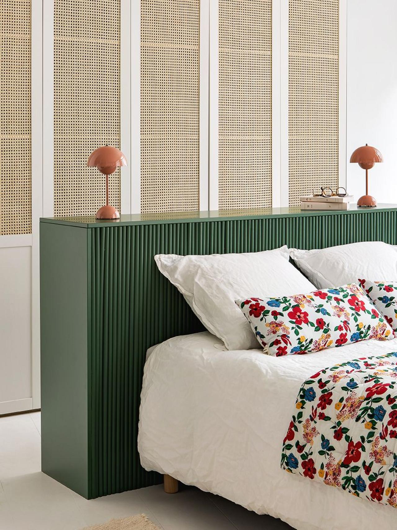Schlafzimmer mit Kleiderschrank aus Rattan und schwebendem Kopfteil in Grün
