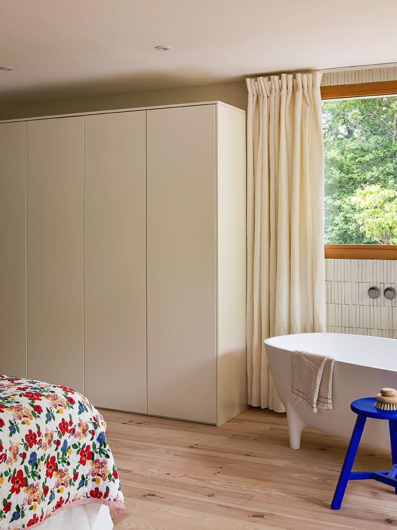 Bright bedroom with waxed concrete and Ivoire wardrobes and bathtub