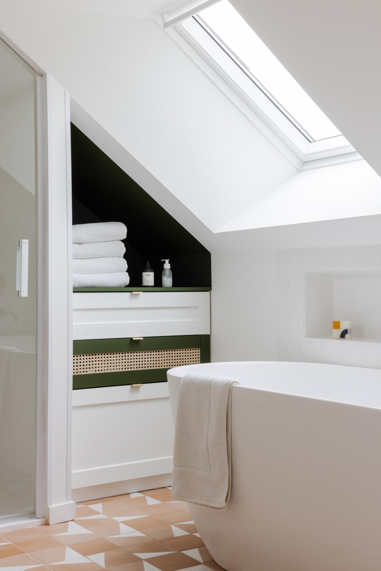 Olive green and white bathroom furniture under the eaves