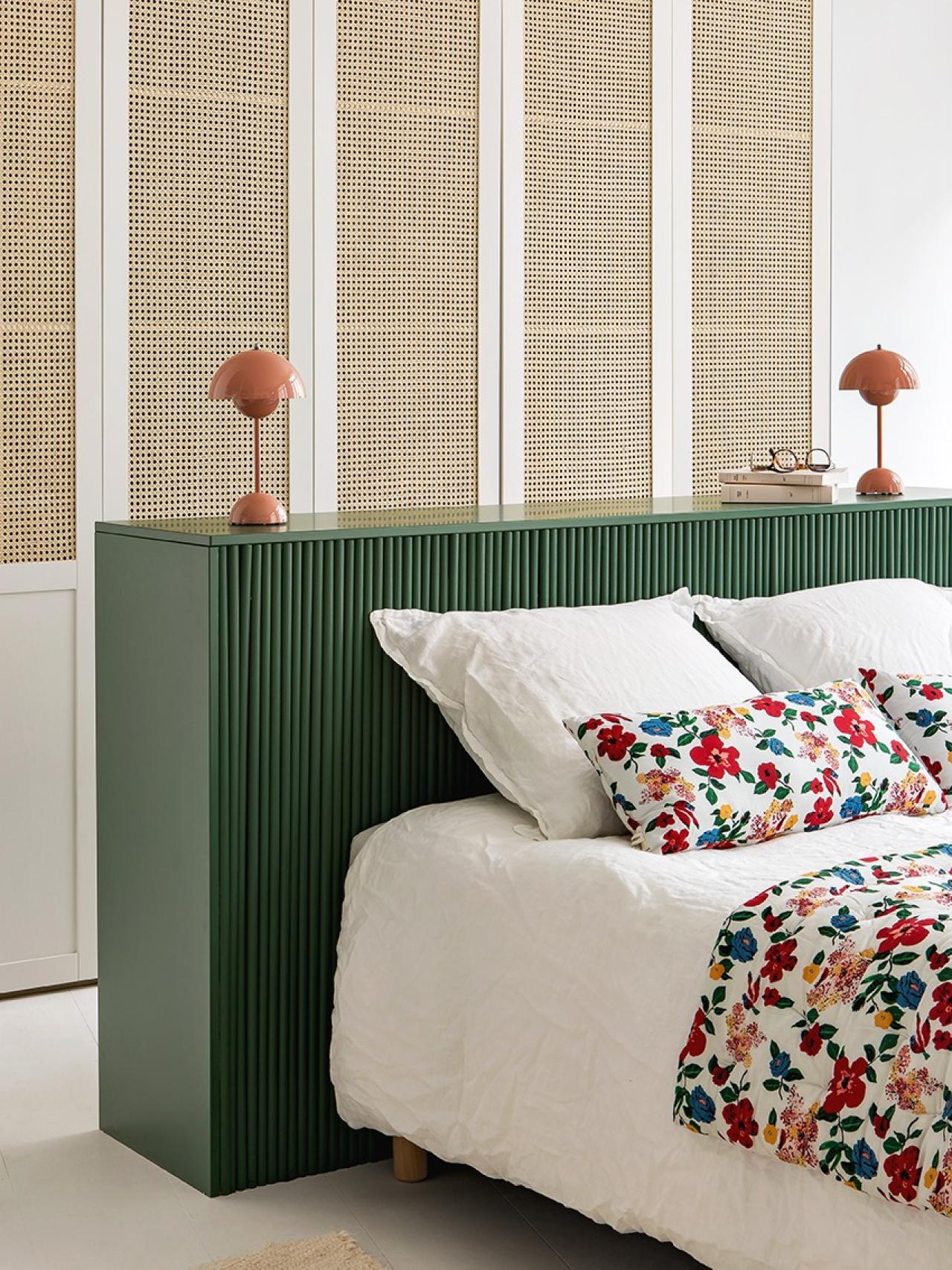 Schlafzimmer mit Kleiderschrank aus Rohrgeflecht und schwebendem Kopfteil in Grün