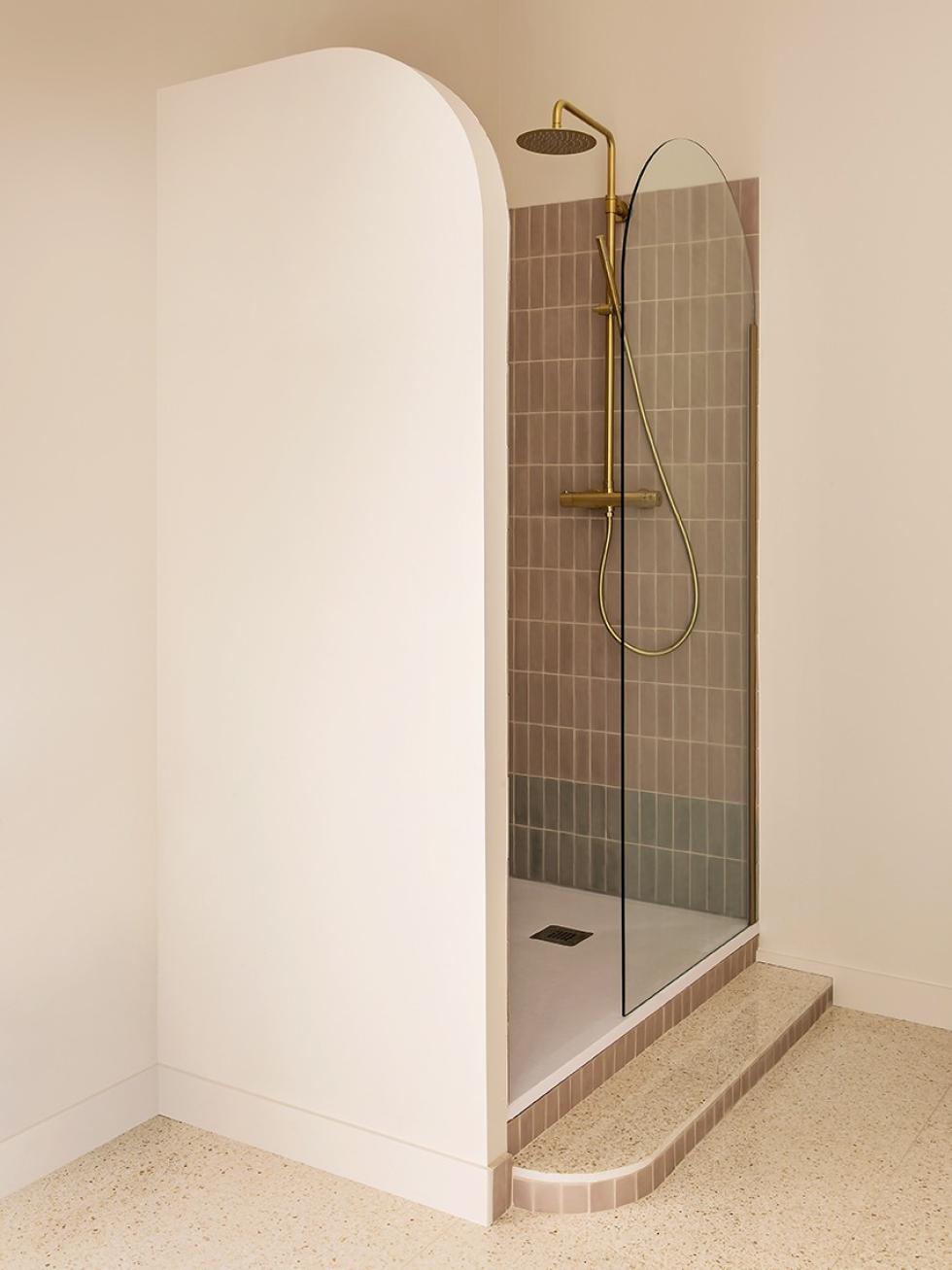 Shower stall with brass taps and rounded details