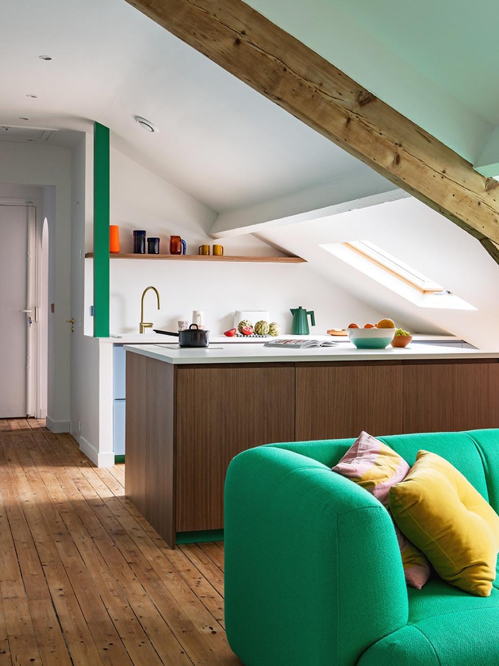 Küche im Dachgeschoss vom Wohnzimmer aus gesehen mit grünem Hay-Sofa im Vordergrund.