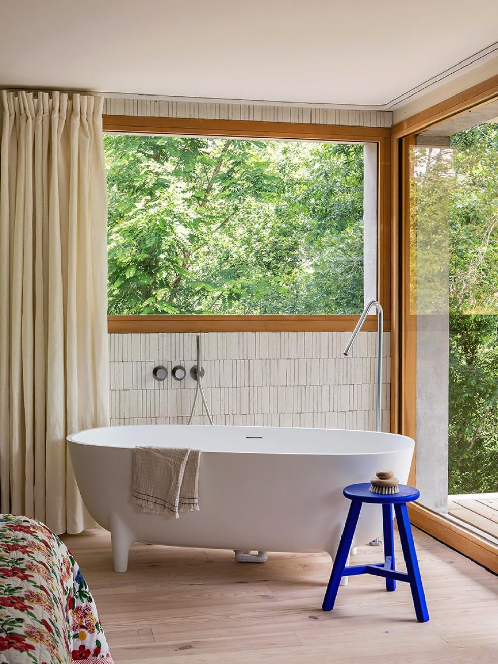 Elternschlafzimmer mit Erkerfenstern und großer Badewanne